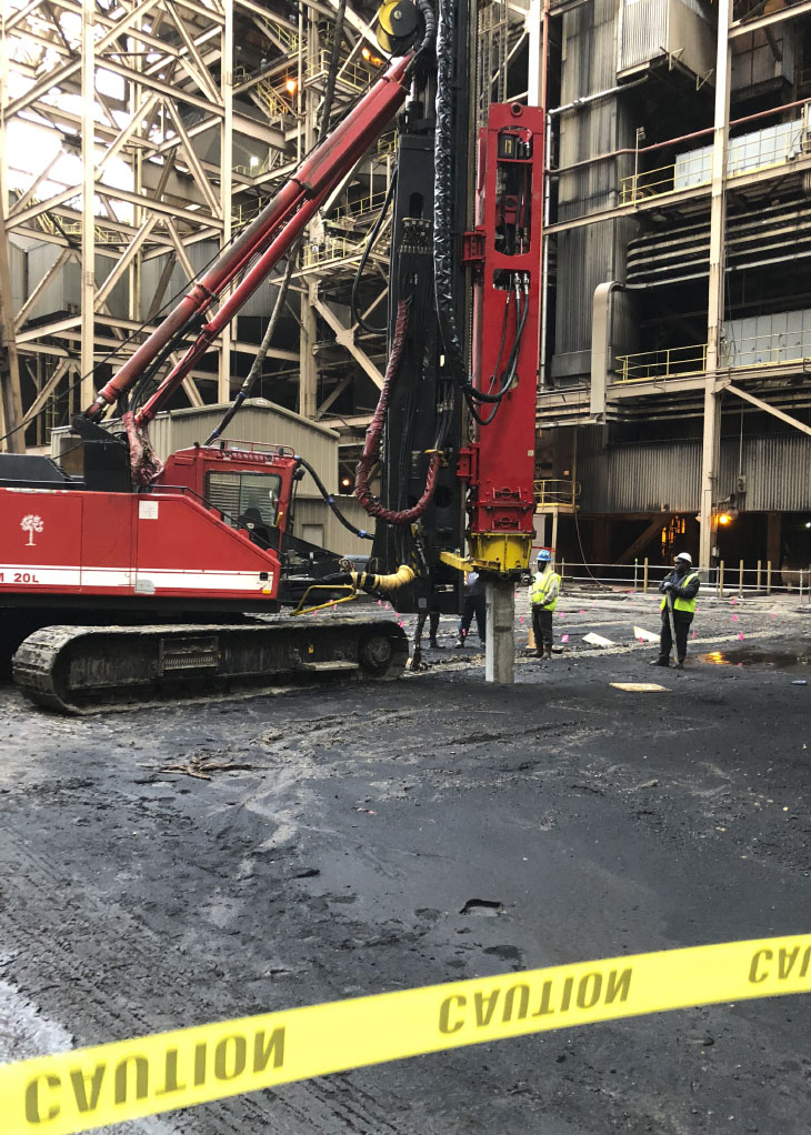 Workers and pile driver on construction site